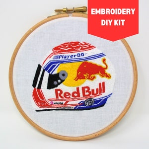 Può includere: Kit fai-da-te per ricamo con un casco da corsa Red Bull con il logo Red Bull e le parole "Player 00" e "Red Bull".