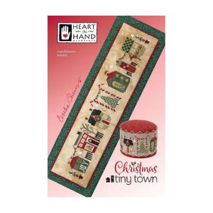 Puede incluir: Un patrón de punto de cruz con un diseño de pueblo navideño en miniatura. El patrón incluye pequeñas casas, árboles y el texto "Christmas tiny town". El diseño está sobre un fondo beige con un borde verde y un acento rojo.