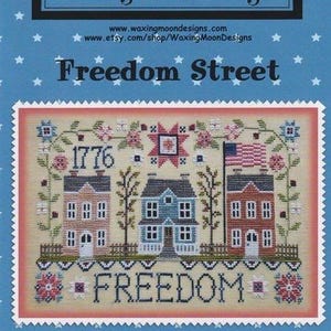 Peut inclure: Un modèle de point de croix intitulé Freedom Street par Waxing Moon Designs. Le motif présente trois maisons, l'année 1776, un drapeau américain et le mot FREEDOM, entourés de motifs floraux sur un fond crème avec une bordure rose.