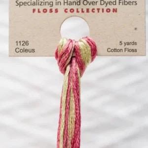 Può includere: Un gomitolo di filo di cotone tinto a mano nei toni del rosa e del giallo, etichettato "1126 Coleus" e "5 yards." Il filo è annodato in alto e pende, mostrando le variazioni di colore. La confezione recita "Specializing in Hand Over Dyed Fibers" e "Floss Collection."