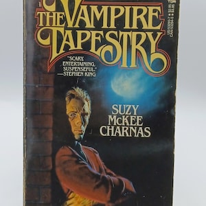 May include: Vintage paperback book cover for "The Vampire Tapestry" by Suzy McKee Charnas. The cover features a man in a red coat, a brick wall, and a blue moon. The title is in gold lettering.