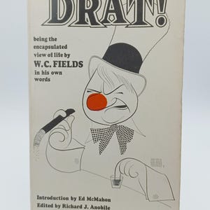 May include: Vintage paperback book cover titled "DRAT!" featuring a cartoon illustration of W.C. Fields. The cover includes the text "being the encapsulated view of life by W.C. Fields in his own words."