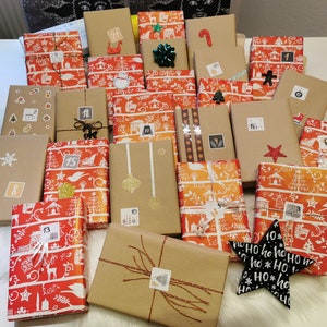 Könnte beinhalten: Eine Auswahl an verpackten Geschenken, einige in braunem Papier und andere in rot-orangefarbenem Musterpapier. Jedes Geschenk ist nummeriert, mit dekorativen Elementen wie Schleifen, Sternen und Aufklebern. Ein schwarz-weißer Stern mit dem Text "Ho ho ho" ist ebenfalls vorhanden.