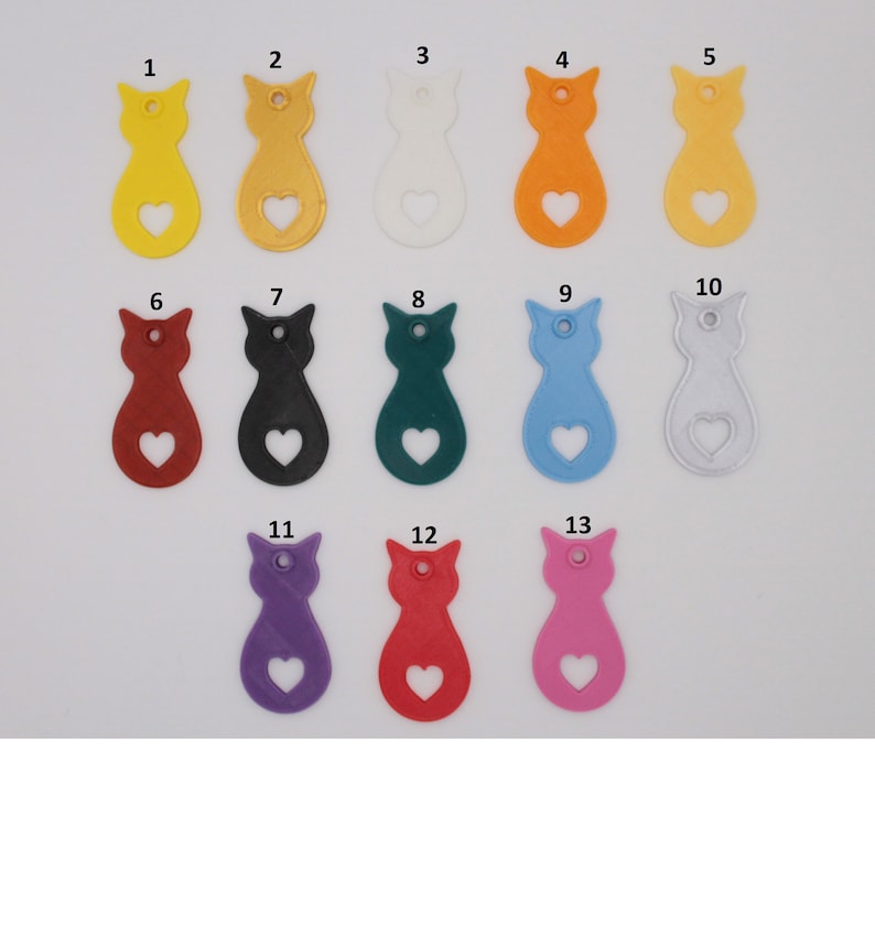 Puede incluir: Trece dijes de pl&aacute;stico con forma de gato en varios colores, incluyendo amarillo, naranja, blanco, rojo, negro, verde, azul, plateado, morado, rosa y rojo. Cada dije tiene un recorte en forma de coraz&oacute;n.