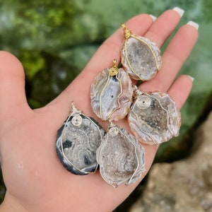 Peut inclure: Cinq pendentifs en cristal d'agate avec un enroulement de fil doré. Les cristaux sont de formes et de tailles différentes et ont un aspect naturel et brut.