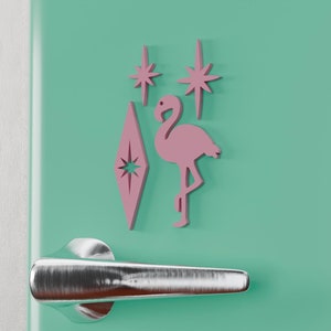 May include: A mint green refrigerator with a silver handle. The refrigerator has a pink flamingo and star decals on the front.