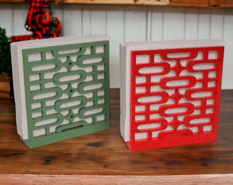 May include: Two decorative wall panels with a geometric design. The panel on the left is green and the panel on the right is red.
