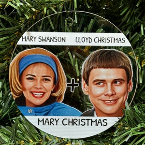 May include: A round, white, acrylic Christmas ornament with a picture of Mary Swanson and Lloyd Christmas from the movie Dumb and Dumber. The text "Mary Swanson + Lloyd Christmas = Mary Christmas" is printed on the ornament.