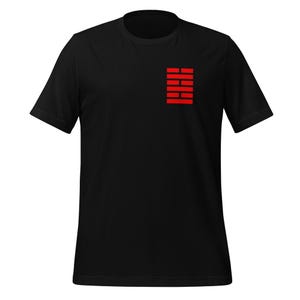 May include: Black t-shirt featuring a red rectangular design on the upper left chest. The design consists of six horizontal red bars stacked on top of each other. The shirt has short sleeves and a crew neck.