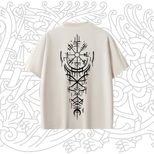 May include: A beige t-shirt with a black graphic of a compass and other symbols on the back.