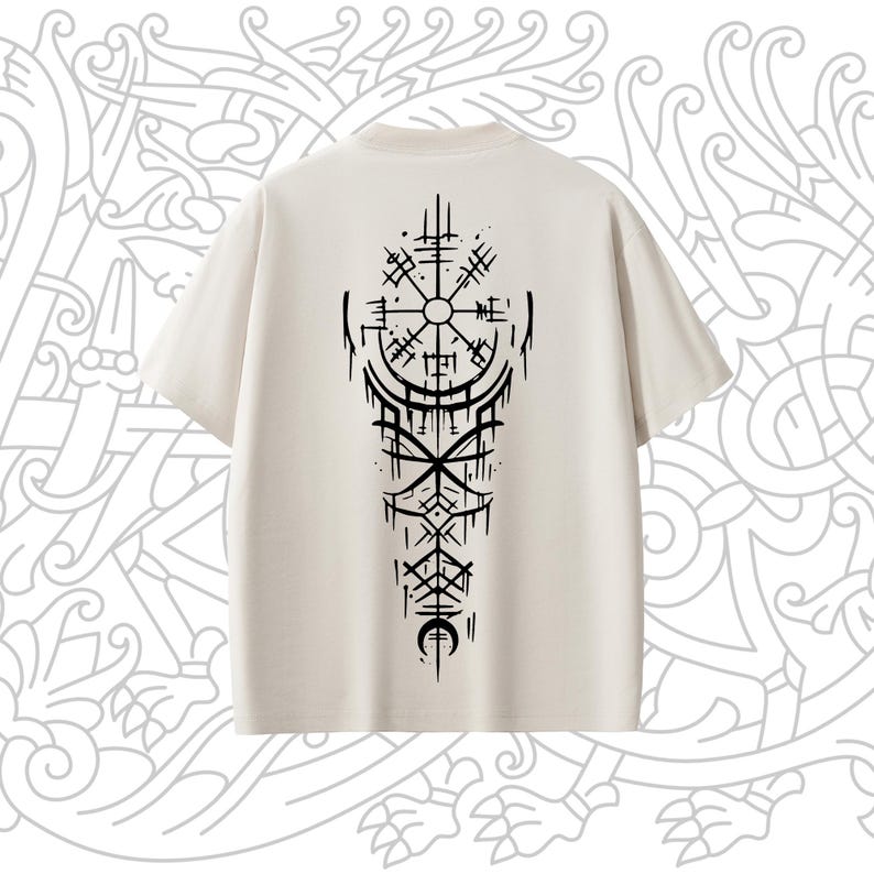 May include: A beige t-shirt with a black graphic of a compass and other symbols on the back.
