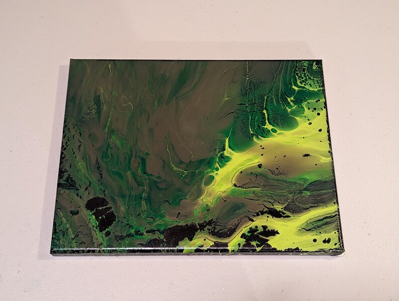 以下が含まれることがあります： 流動的なデザインの抽象芸術作品。この作品は、濃い緑色、オリーブグリーン、ネオンイエローの色合いを組み合わせており、ダイナミックで質感のある外観を作り出しています。黒のアクセントが構成に深みを加えています。長方形の作品です。