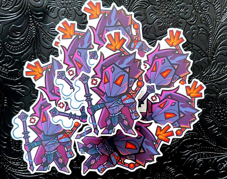 May include: A collection of stickers featuring a stylized, cartoonish character in purple, blue, and orange armor. The character holds a staff and has a geometric design. The stickers have a white border and are arranged on a black, textured surface.
