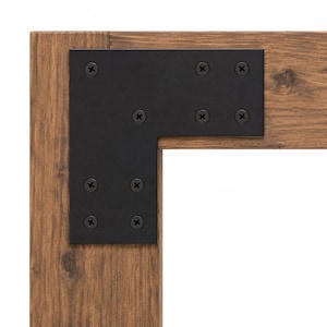 May include: An L-shaped black metal corner bracket secured with eight black screws onto a light brown wooden frame. The bracket features a matte finish and is positioned at the intersection of two wooden beams with visible wood grain texture.