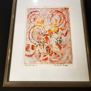 May include: Framed abstract art print in red, orange, and yellow tones with a white background. The print is titled "Red Sparks Monotype" and signed by the artist "Elizabeth O'Kelly, '73".