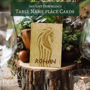 May include: A rustic table name place card with a horse design and the name "ROHAN" in brown. The card is set on a wooden slice with greenery and glassware in the background. Text at the top reads "INSTANT DOWNLOAD Table Name Place Cards".