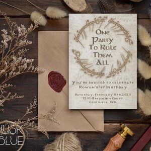 May include: A white invitation card with a gold ring design and the text "One Party To Rule Them All". The card is decorated with a wax seal and is surrounded by dried flowers and a brown envelope.