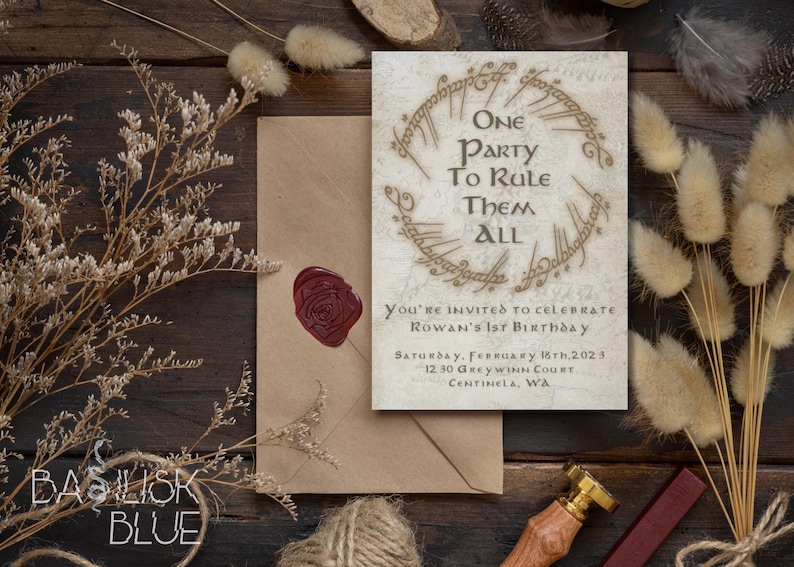 May include: A white invitation card with a gold ring design and the text "One Party To Rule Them All". The card is decorated with a wax seal and is surrounded by dried flowers and a brown envelope.