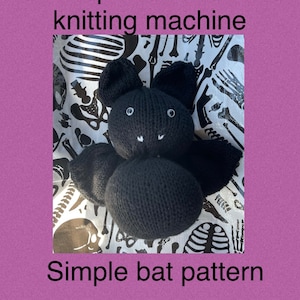 Puede incluir: Un juguete de murciélago de punto negro sobre un fondo blanco con un patrón de esqueleto. El juguete está hecho en una máquina de tejer circular de 48 agujas. "Patrón de murciélago simple" está escrito debajo de la imagen.