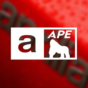 May include: White sticker with the word "APE" in all caps and a silhouette of a gorilla. The sticker also has the letter "a" in a larger font.