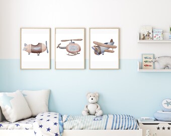 May include: Three framed watercolor prints of vintage airplanes and a helicopter. The artwork features a biplane, a helicopter, and a propeller plane in soft brown, blue, and beige tones. The prints are displayed in a child's bedroom.