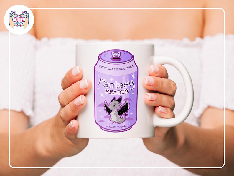 May include: White ceramic mug featuring a purple can design with the words "Fantasy Reader" and a cartoon dragon illustration. The mug also includes the text "Emotional Support Drink" and "18 fl oz (530 ml)".