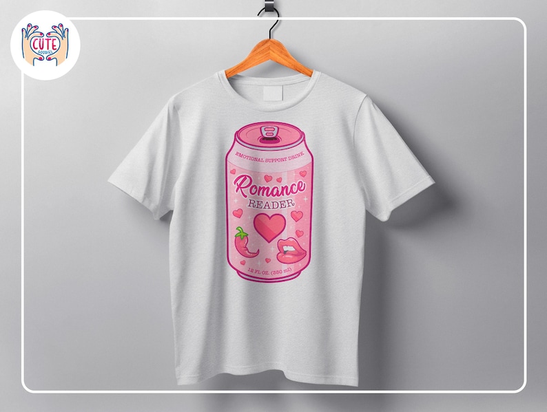 May include: White t-shirt featuring a pink soda can design. The can reads "Romance Reader" with hearts, a chili pepper, and lips. The can is labeled "Emotional Support Drink" and has a volume of 12 fl oz (360 ml).