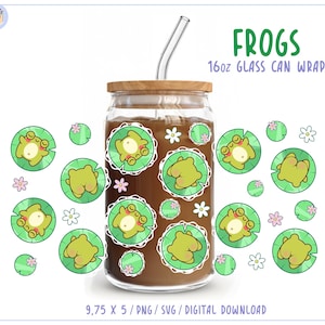 May include: A clear glass can wrap with a wooden lid, filled with a brown liquid, and a glass straw. The wrap features a repeating pattern of cartoon frogs on lily pads and the text "FROGS 16oz GLASS CAN WRAP".