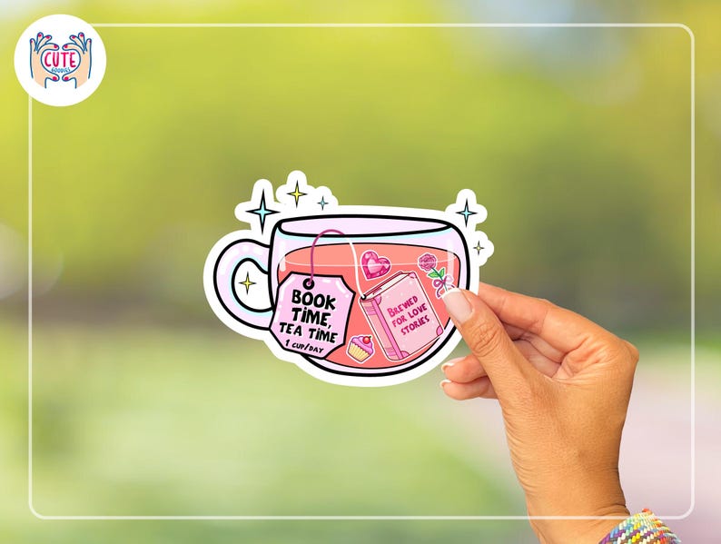 May include: A sticker featuring a teacup filled with pink tea. The teacup has a tag that reads "BOOK TIME, TEA TIME, 1 CUP/DAY." Inside the cup is a book that says "BREWED FOR LOVE STORIES." The sticker is held by a hand.