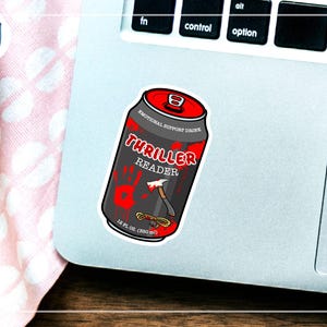 May include: A sticker of a black can with red accents, labeled "Thriller Reader" with a bloody handprint and an axe graphic. The can is labeled "Emotional Support Drink" and "12 fl oz (350 ml)".