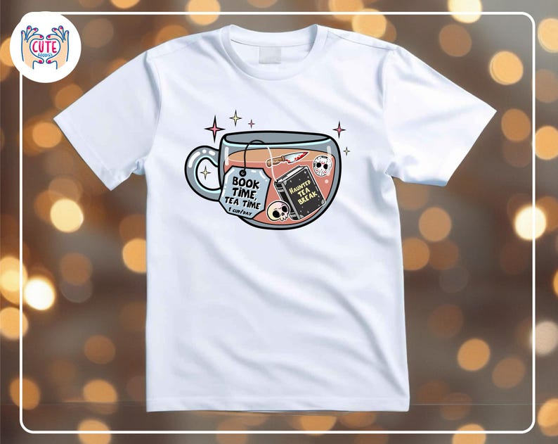 May include: White t-shirt featuring a whimsical design of a teacup filled with a book, knife, and skulls. The teacup has the text "Book Time, Tea Time" and a tag that says "I can't wait". A book in the teacup says "Haunted Tea Break".