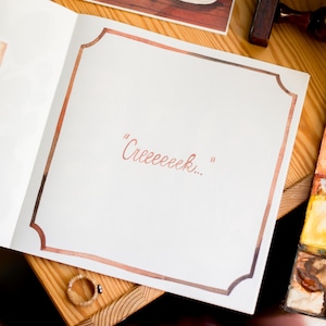 May include: A white page with a brown border, the words "Creceeeek..." are written in pink on the page.