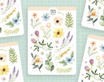May include: A sheet of stickers featuring watercolor illustrations of various flowers and foliage. The stickers are on a white background and include lavender, clover, ferns, and daisies in shades of pink, blue, yellow, and green. The text "Wild Pencil" is written in cursive at the top of the sheet.