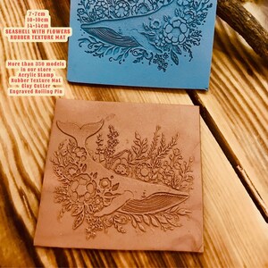 May include: A brown rubber texture mat with a whale and flowers design. The mat is 14 inches by 14 inches. The text "SEASHELL WITH FLOWERS" is printed on the mat.