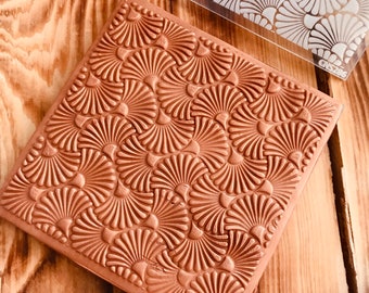May include: A brown rubber stamp with a repeating pattern of stylized flower shapes. The stamp is labeled "CNS 288".