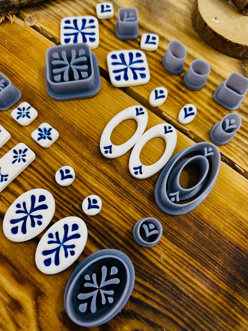 May include: A set of 17 blue and white ceramic tile molds. The molds are in various shapes, including squares, ovals, and circles. The molds are made of a durable plastic material and are perfect for creating beautiful and unique tiles.