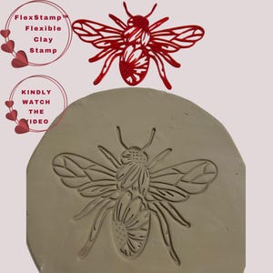May include: A red bee-shaped FlexStamp with a matching impression in clay. The stamp is above the clay impression. Text on the left says "FlexStamp Flexible Clay Stamp" and "Kindly Watch The Video".