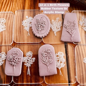 Può includere: Dodici timbri in gomma o acrilico da 2,5 cm di diametro con motivi floreali. I timbri sono disposti su un foglio di acrilico trasparente. Il testo "12 in 1 Birth Flowers Rubber Texture Or Acrylic Stamp" è visibile nella parte superiore dell'immagine.