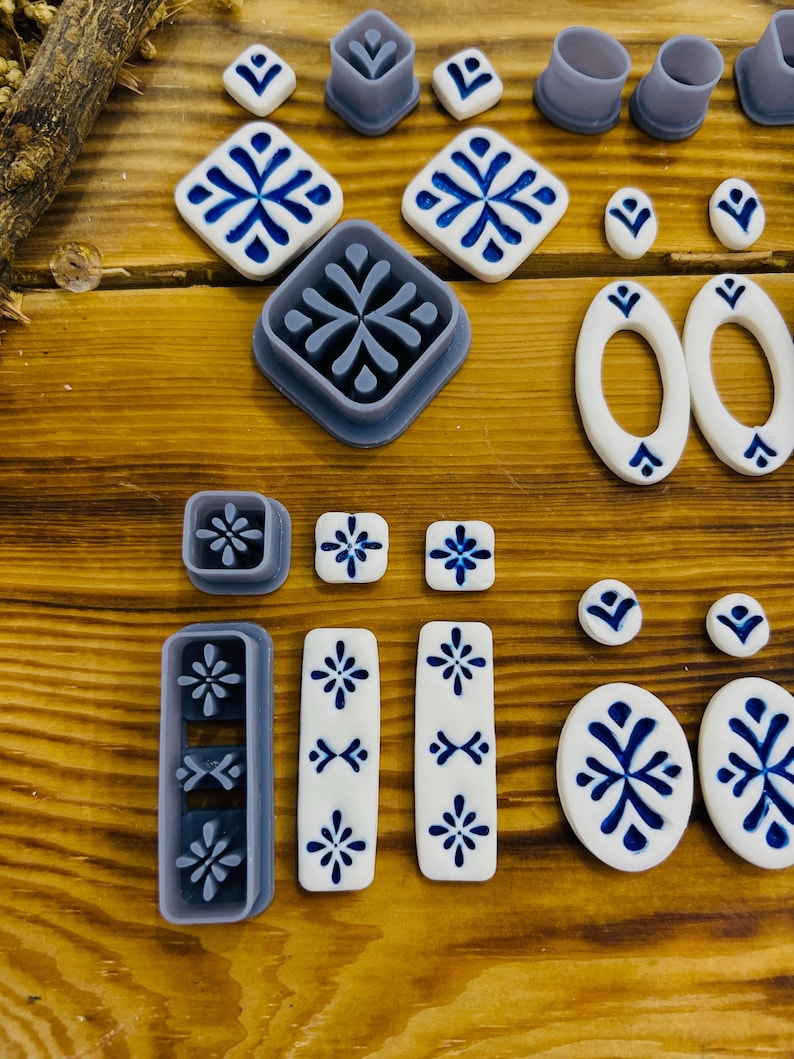 May include: A set of 16 blue and white ceramic tile cookie cutters. The cutters are in various shapes, including squares, rectangles, ovals, and circles. The cutters are made of durable plastic and are perfect for creating decorative cookies.