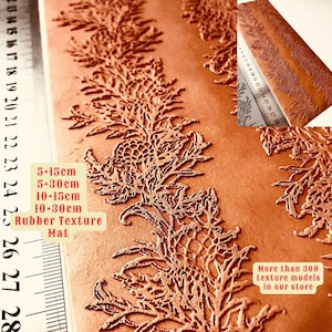 Peut inclure: Un gros plan d'un tapis en cuir brun texturé avec un motif floral. Le tapis mesure 25 cm sur 76 cm. Le texte "Rubber Texture Mat" est imprimé sur le tapis. Le texte "Plus de 300 modèles de textures dans notre boutique" est imprimé dans le coin inférieur droit de l'image.