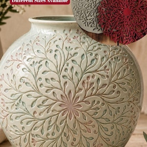 May include: A round ceramic vase with a light green glaze and a relief-carved botanical mandala pattern. In the upper corner, a circular inset shows a grey and a red flexible stamp with the text Flexstamp Botanical Garden Mandala Stamp.