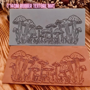 May include: A 7x14cm rubber texture mat with a design of a row of mushrooms. The mat is shown in both its original gray color and after being used to create an impression in a brown clay surface.