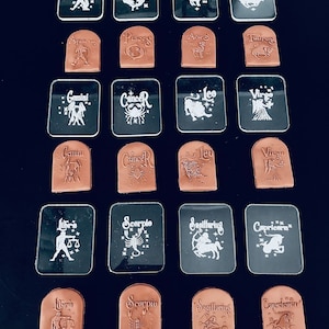 Può includere: Set di 12 timbri con i segni zodiacali, con timbri in acrilico trasparente e in pelle marrone. Ogni timbro presenta un simbolo zodiacale unico, tra cui Acquario, Pesci, Ariete, Toro, Gemelli, Cancro, Leone, Vergine, Bilancia, Scorpione, Sagittario e Capricorno.