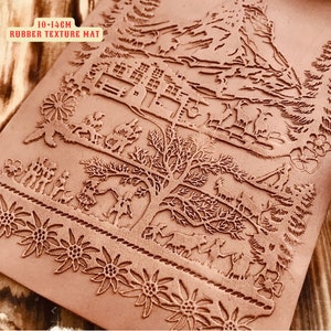 May include: A brown rubber texture mat with a detailed relief design. The mat features a mountain scene, a tree, and figures of people and animals. The text "IO-14CM RUBBER TEXTURE MAT" is visible. The mat measures 10-14 cm.