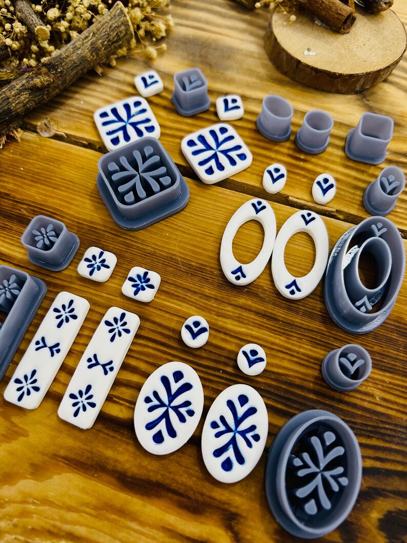 May include: A set of 18 polymer clay cutters in various shapes and sizes, including circles, ovals, squares, and rectangles. The cutters are gray and feature a white and blue geometric design.
