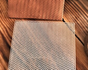 May include: A clear acrylic stamp with a chevron pattern. The stamp is designed for use with crafting projects.