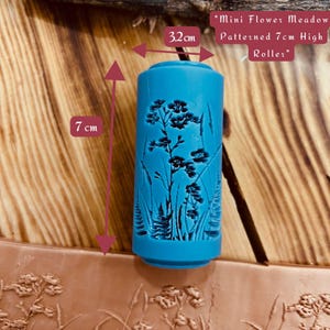May include: A blue rolling pin with a floral pattern, measuring 7 inches tall and 32 inches long. "Mini Flower Meadow Patterned 7cm High Roller"