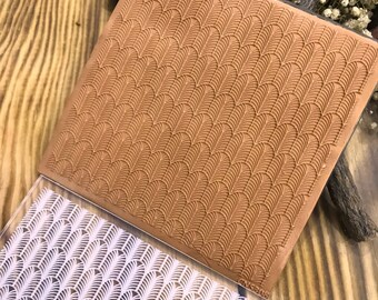 May include: Two clear acrylic stamps with a geometric pattern of overlapping arches. The top stamp is brown and the bottom stamp is white.