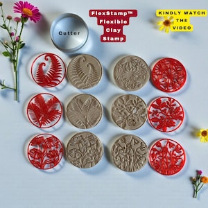 May include: A collection of flexible clay stamps and a cutter. The stamps feature various botanical designs, including ferns and floral patterns, in red and tan. The cutter is a silver cylinder with the word "Cutter" printed on it. The text "FlexStamp Flexible Clay Stamp" is also visible.