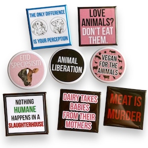 May include: Eight vegan and animal rights themed buttons with various slogans. The buttons are round and square, with black, white, pink, and brown backgrounds. The slogans include "Love Animals? Don't Eat Them." "End Speciesism" "Animal Liberation" "Vegan For The Animals" "Nothing Humane Happens In A Slaughterhouse" "Dairy Takes Babies From Their Mothers" and "Meat Is Murder."